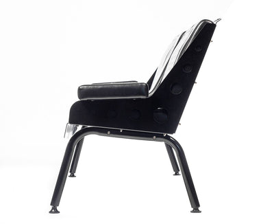 Side view of the black Comfort Before Pain Waiting Room Bench for tattoo shops highlighting the bench's metal frame. 