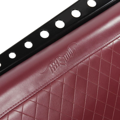 A close-up of the metal frame & embossed TATSoul logo on an Ox Blood waiting bench. This is the Comfort Before Pain Waiting Room Bench. 